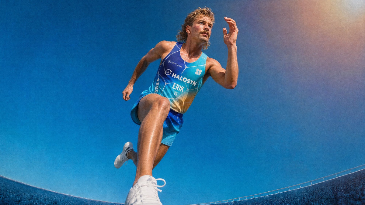 Runner sprinting in a gradient blue singlet, seen from below