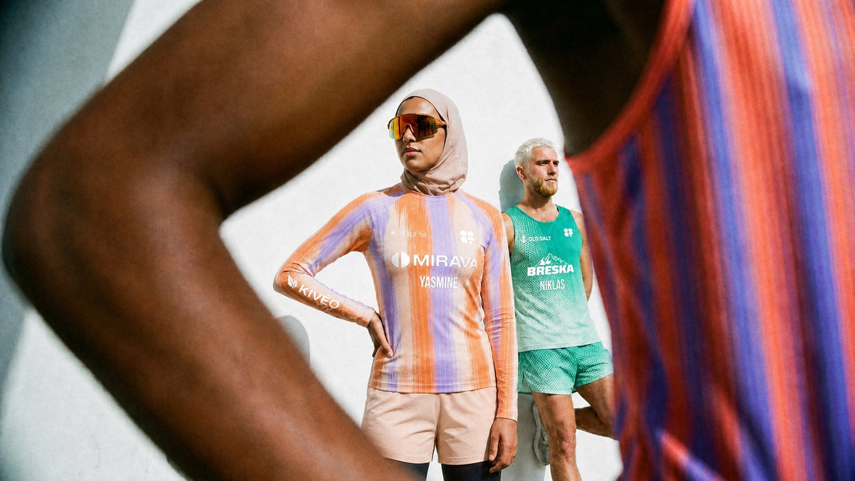 Two athletes posing in an orange-and-lilac striped top and a mint-green singlet